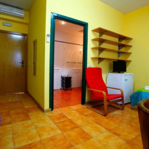 Interior de dormitorio con una cama y paredes en color amarillo